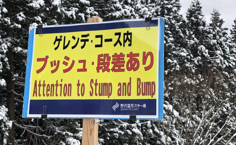 Photo of sign warning skiers in Japanese and English to "beware of stump and bump"